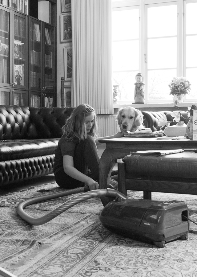 Robin Isabella von Overgaard cleaning the living room in Villa Nøjsomheden, 2018. © Thorsten Overgaard. 