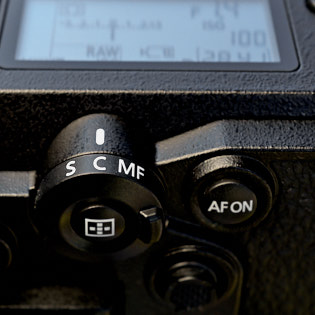 Focusing buttonsThere is a S (single focus), C (continious focus) and a MF (Manual Focus) selection on this. In the center is a button for activating focus aid. This button works also when the Lock button is turned on (the one that loks all buttons on the camea).AF ONActivates AF if you want to activate AF without touching the shutter release button (!).