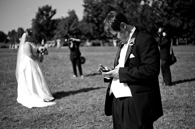 A bride fighting with her white balance appearance in Philadelphia in July 2011 while her new husband is updating his relationship-status on Facebook. © Thorsten Overgaard.