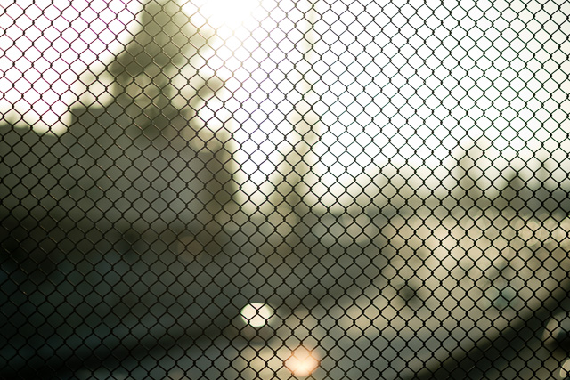 The same fence with sunset behind it. Not the sun in top of the frame, and a reflection in the bottom of the frame. 1/750 with 3-stop ND filter (1/6000 without ND filter). Leica M10 with Leica 75mm Noctilux-M ASPH f/1.25. © 2018 Thorsten von Overgaard.