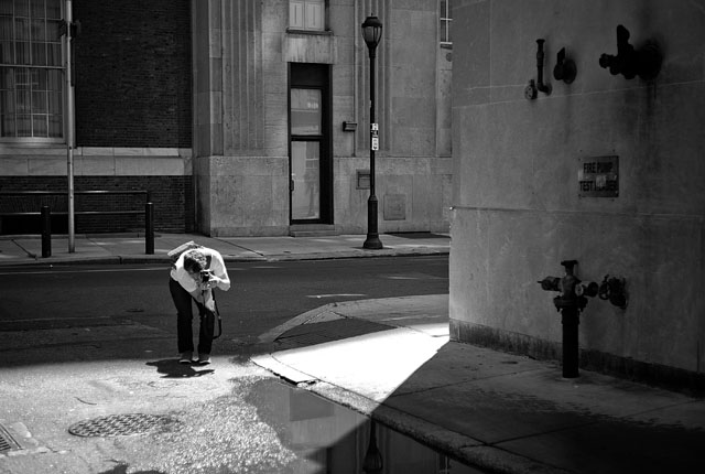 A photographer dealing with light and reflections in Philadelphia   