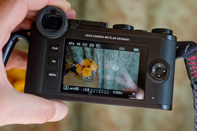 The Leica CL has a touch screen. If you press the button in the center to the right of the screen, you change the view of information on the screen, from no text at all, to all information. On this screen you can see (clockwise from top left) that the auto focus is set to AF Single point, the white balance is set to Auto White Balance, the camera shoots in DNG format only, the light metering symbol tell that the calea is set to Multi Field, and the next synbol of multiple frames tell it is set to Continious shooting. The look of the preview (and JPG files if the camera takes JPG files at the same time as DNG, is set to STD (standard; and not saturated, monochrome or other). Battery synbol tells the battery is full.  From left to right in the bottom, the mode is set to Aperture priority, the ISO is set to 400, the lens is set to f/2.8. The exposure white dot in the middle of the scale shows that I am not adjusting the exposure. 1/200 sec is the exposure time, and I have 1K (1,000) pictures left on the memory card. 