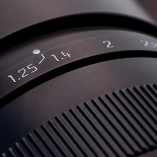 f/1.25  The aperture ring for the Leica 75mm Noctilux features an f/1.25 as the widest opening. Simply for space reasons the 1.25 is placed to the left of 1.4 and the actual position on the scale is marked with a white line.   Aperture normally goes from f/1.0 to f/1.4 to f/2.8 and so on, with each step reducing the light to half of the previous step. f/1.25 is mid-way between f/1.0 and f/1.4; a "half-stop".   Aperture ring is sometimes called diaphragm ring (dia=through, phragma=fence) as it controls how much light comes through the lens. 