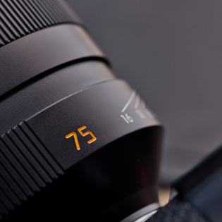 Focal length marking  In recent years, all Leica lenses have gotten an orange marking on the barrel with the focal length so the user can see which lens is mounted on the camera. In this case a 75mm lens. 