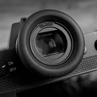 Leica SL2 Eye sensor

The small arc-shaped window above the viewfinder is a sensor that detects if a hand or eye is in front of the viewfinder. The idea is that when you take the camera to your eye, the viewfinder EVF is activated and the screen on the back is turned off. 
