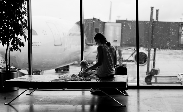 Mother with newborn baby in Copenhagen Airport, enjoying the view to rain and travel. Leica TL2 with Leica 35mm Summilux-TL ASPH f/1.4. © 2017 Thorsten Overgaard.