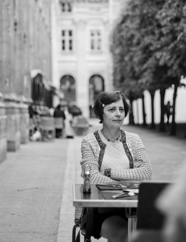 The school of life: In the gardens of Le Palais Royal opposite Louvre in Paris one can sit and zone out when the rest of Paris is too much people and noise. That's the point we reached after a long day. Here one can sit by what looks like a school table and study people kissing, talking, reading, running and kids playing. © 2014 Thorsten Overgaard.Leica M 240 with Leica 50mm Summicron-M f/2.0 II. (No, it's not Vivan Maier).