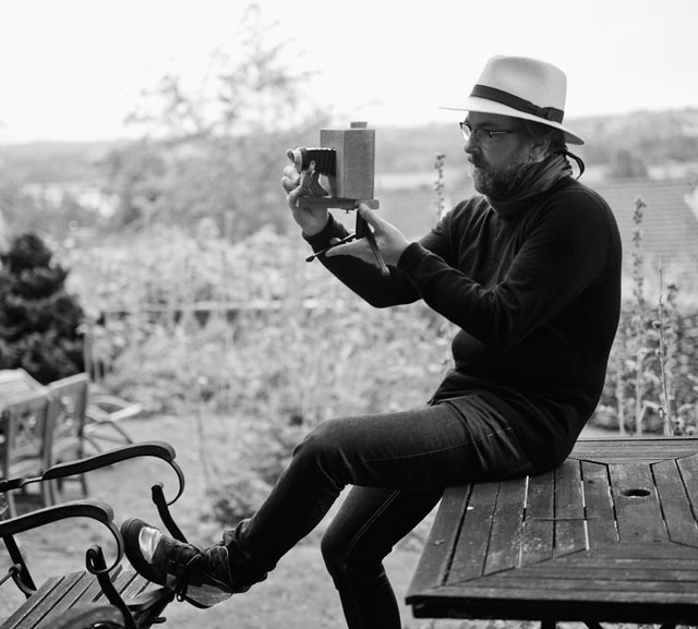 Thorsten Overgaard in the garden in 2014 with a wooden camera he built in the basement of Villa Nøjsomheden in 1980.