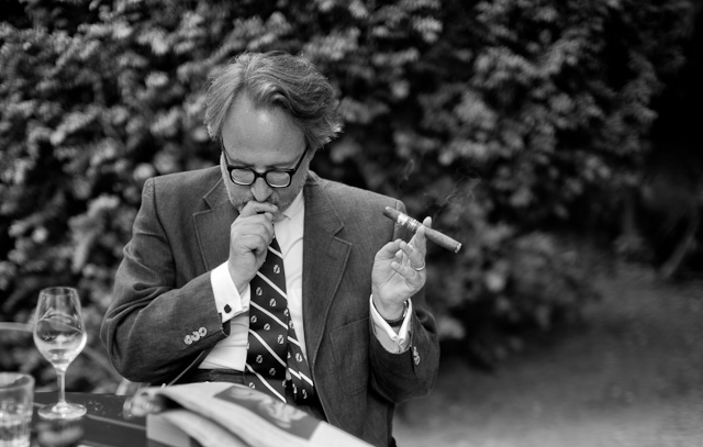 The beautiful greytone range of a man reading the newspaper and smoking a cigar in soft daylight in a Berlin garden. Leica M246 with Leica 50mm Noctilux-M ASPH f/0.95. © Thorsten Overgaard. 