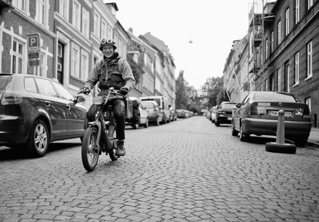 A retro-moment as a Danish guy departs for a music festival on his 1970's PUCH Maxi in July 2015. It's actually in Hjemensgade in Aarhus where I used to go to school (the buildings to the right in the picutre).  Leica M 246 with Leica 28mm Summilux-M ASPH f/1.4. © 2015 Thorsten Overgaard.