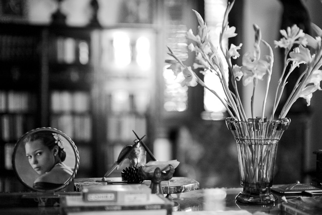 What is Depth of Field? In this photo, the focus is on the flowers and the photograph on the desk, while the foreground and background are blurred due to the narrow depth of field. If you stop down the aperture of the lens from f/1.7 to f/5.6, more elements will come into focus. If you further stop down the lens to f/11, even more will be in focus. Another rule to remember is that the closer you get to a subject (reducing the focusing range), the narrower the depth of field becomes. © Thorsten Overgaard.