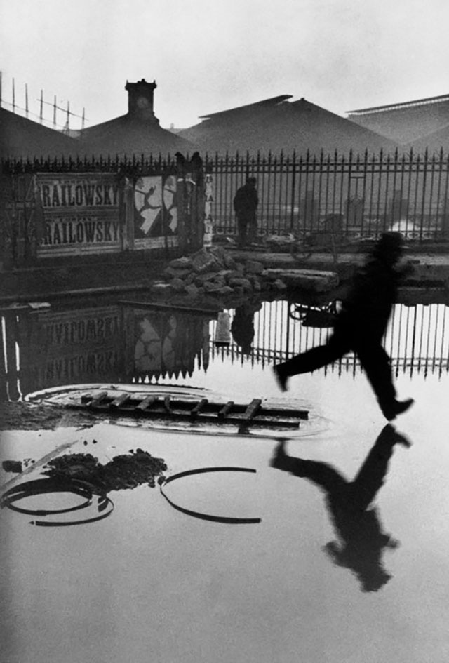 Henri Cartier-Bresson "Behind Saint Lazare" , or simply known as The Jumping Man, taken in Paris in 1932, taken with his first Leica, the Leica-Couplex (Leica D) with the 50mm Elmar f/3.5. Read my re-visit to the location in 2017, trying to recreate a similar scene, "Behind Saint-Lazare". 