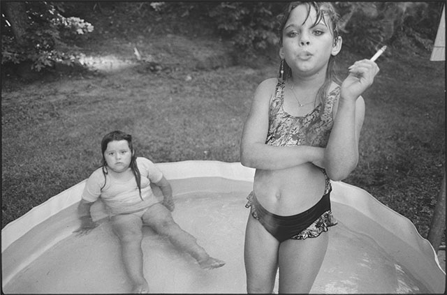 In 1990 Mary Ellen Mark (1940-2015) photographed "The Smoking Girl" with her Leica M6. The girl is Amanda Marie Ellison, 9 (and Amy Minton Velasquez, 8 sitting) in the "Sin City" disctict of Valdese, N.C. for LIFE magazine abotu a school for "problem children" .