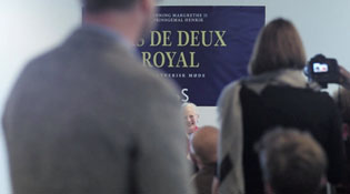 The instant Joy asks the Queen a question, of all people, the press officer of the event stands in front of the camera. Who could have imagined? 