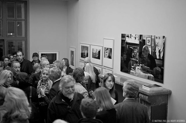 Guests at the vernissage. The large image over the fireplace is "The Couple" taken inside the Paris Bar in Berlin (the wife holding a knife aginst her husband. Photo by Matthias Frei.